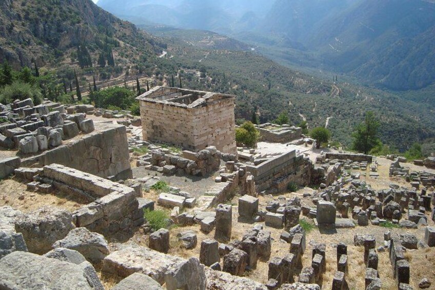 Ancient ruins with stone blocks and walls, set against a mountainous backdrop. 2
