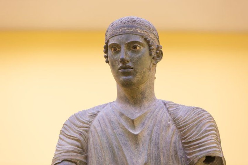 Eine Statue mit flatternden Gewändern und einem Stirnband. 5