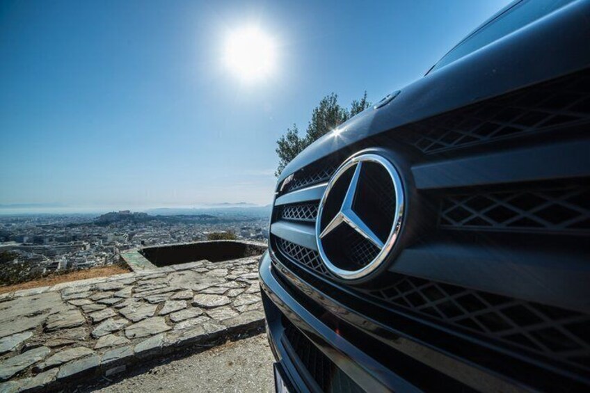 Parrilla frontal de un automóvil Mercedes-Benz con un paisaje urbano de fondo. 3