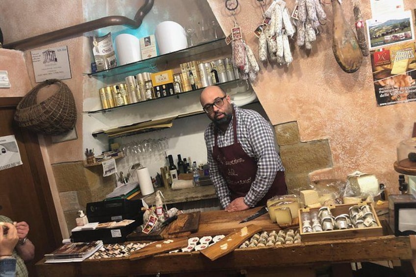 Una persona en un mostrador con diferentes alimentos y salsas. 3