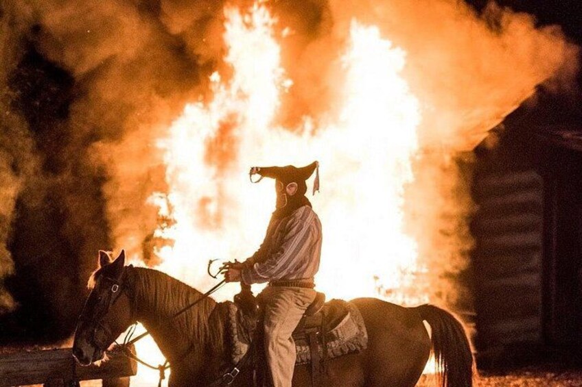 Una persona a caballo con un objeto llameante al fondo. 1