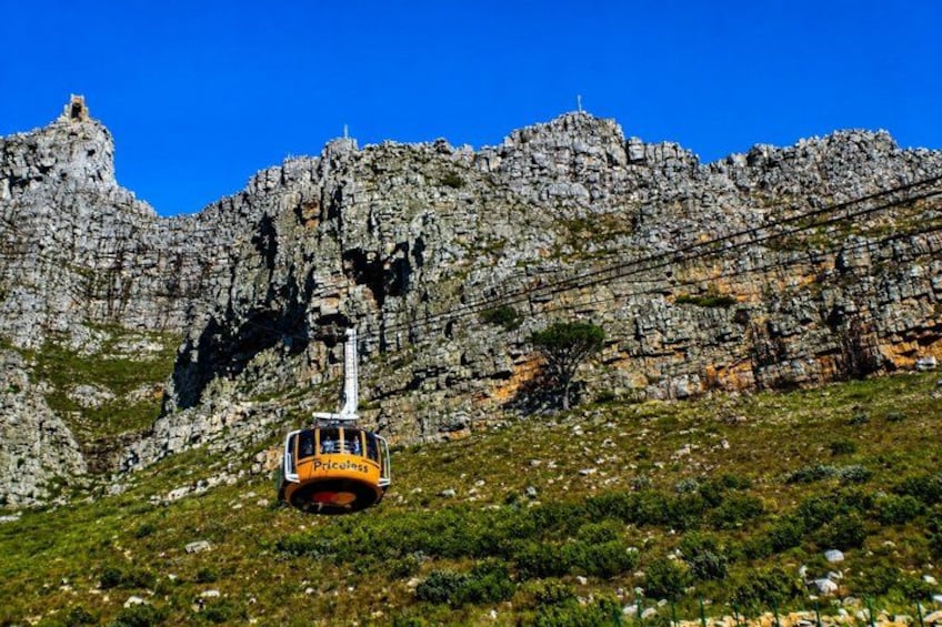 A cable car at the base of a rocky mountain. 3