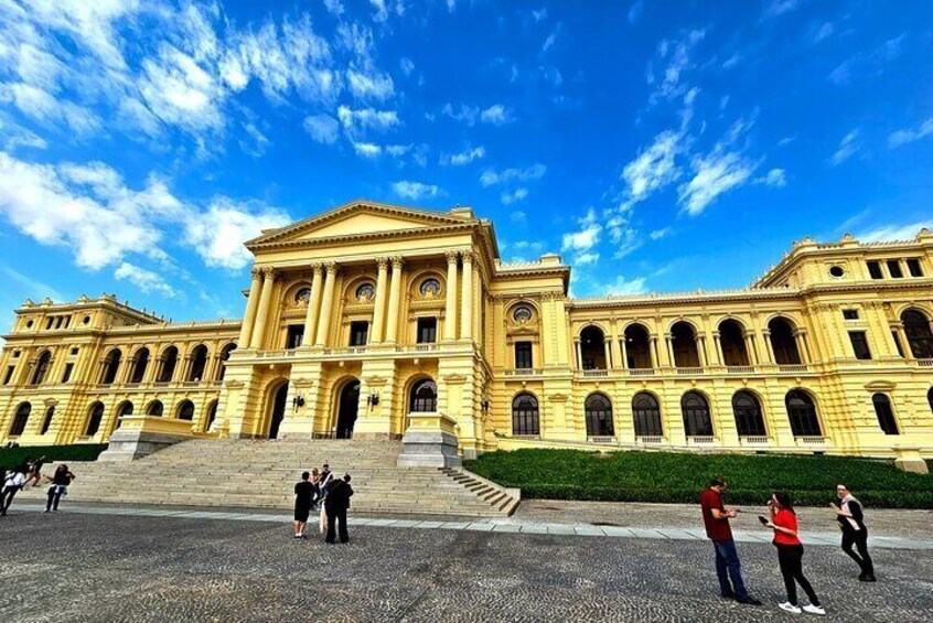 A large classical building with a central entrance and multiple arches. 1