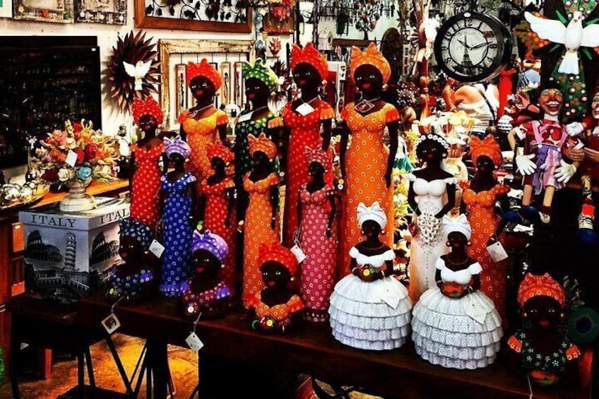 A collection of dolls and figurines, some with hats and others with accessories, displayed on shelves. 4