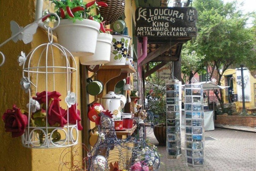 A ceramic shop with various pottery items and a signboard. 1