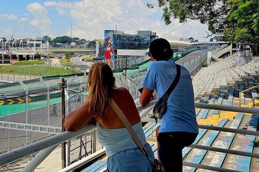 A stadium with empty stands, a person taking a photo, and a person looking at a phone. 5