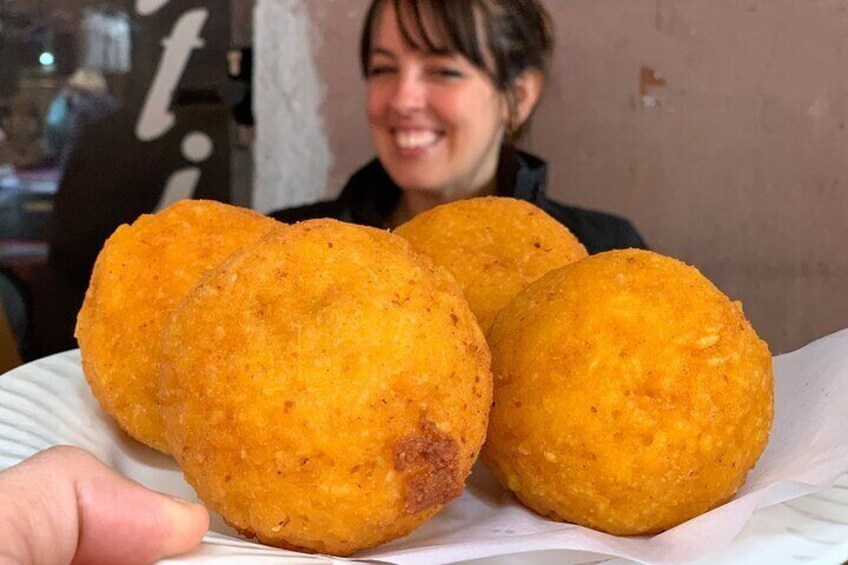 Three golden-brown fried balls on a white plate. 4