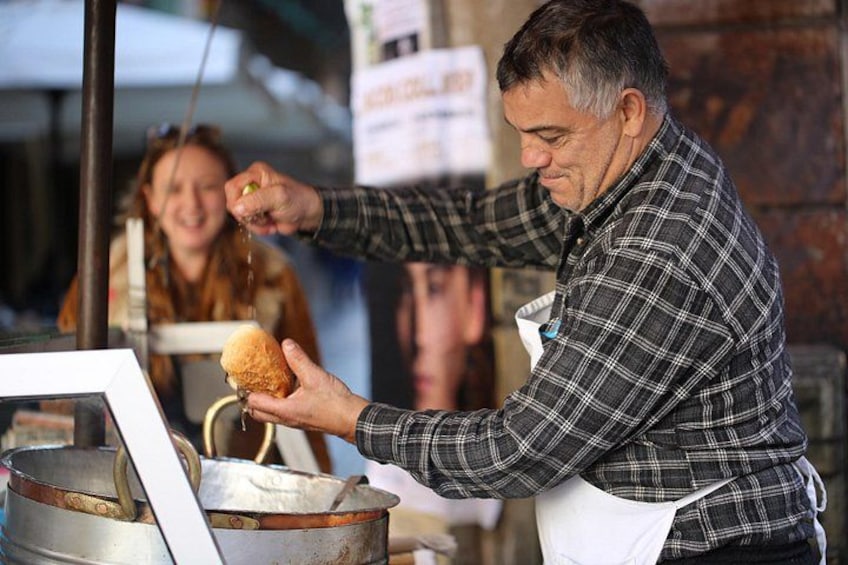 Eine Person bereitet Essen zu, möglicherweise brät sie etwas, eine Pfanne und ein Berliner sind zu sehen. 5