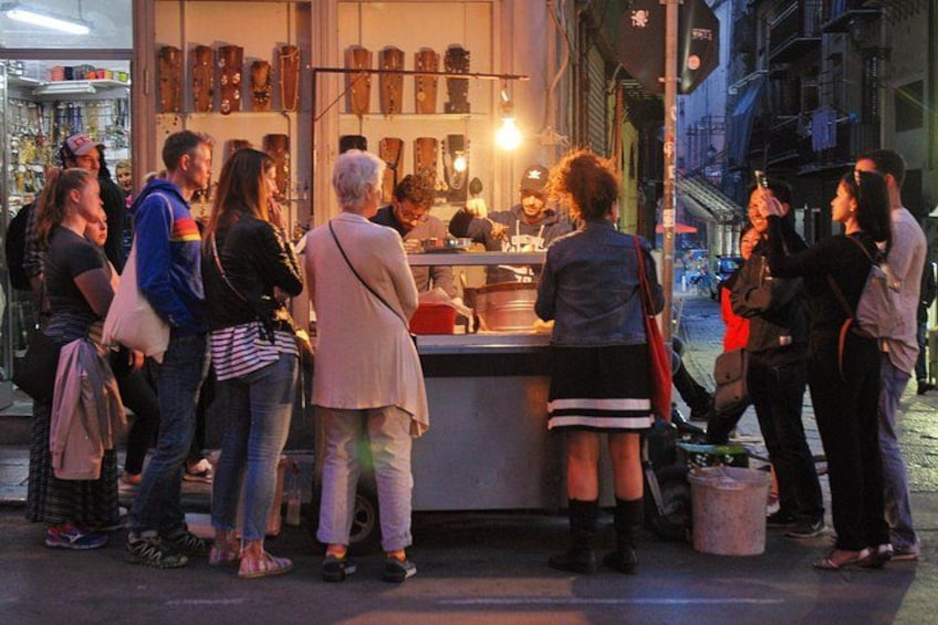 A street food vendor with a crowd of people around. 2