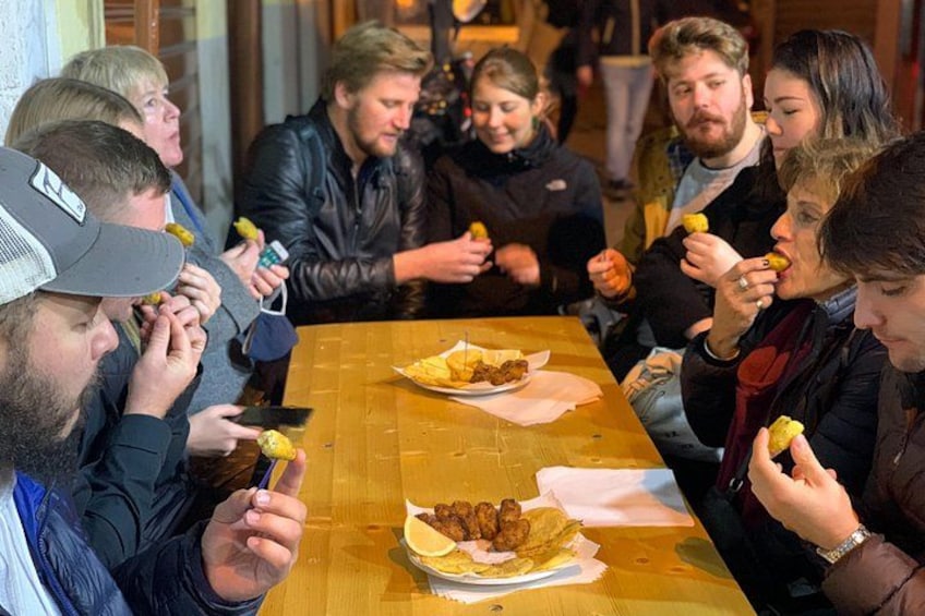 En gruppe mennesker sidder ved et træbord og spiser. 2