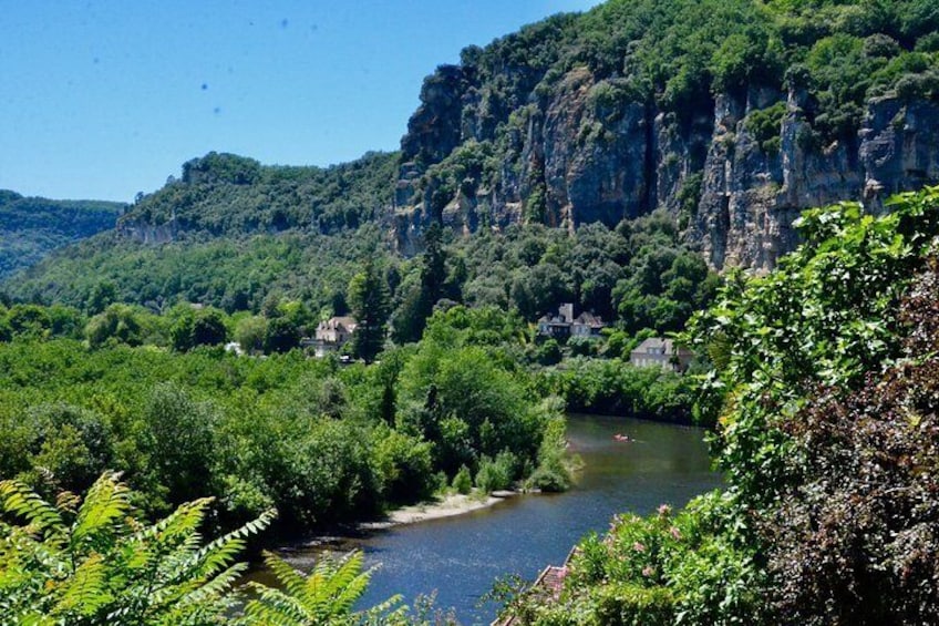 A river flowing through a valley with dense greenery and rocky cliffs. 1