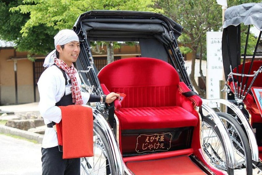 A red rickshaw with a driver, a sign with Japanese characters, and a traditional building in the background. 4