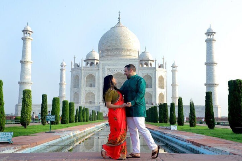 A couple standing in front of the Taj Mahal. 1