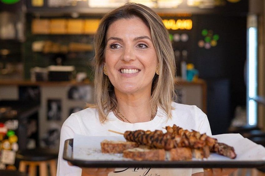 A person holding a tray with grilled meat. 1