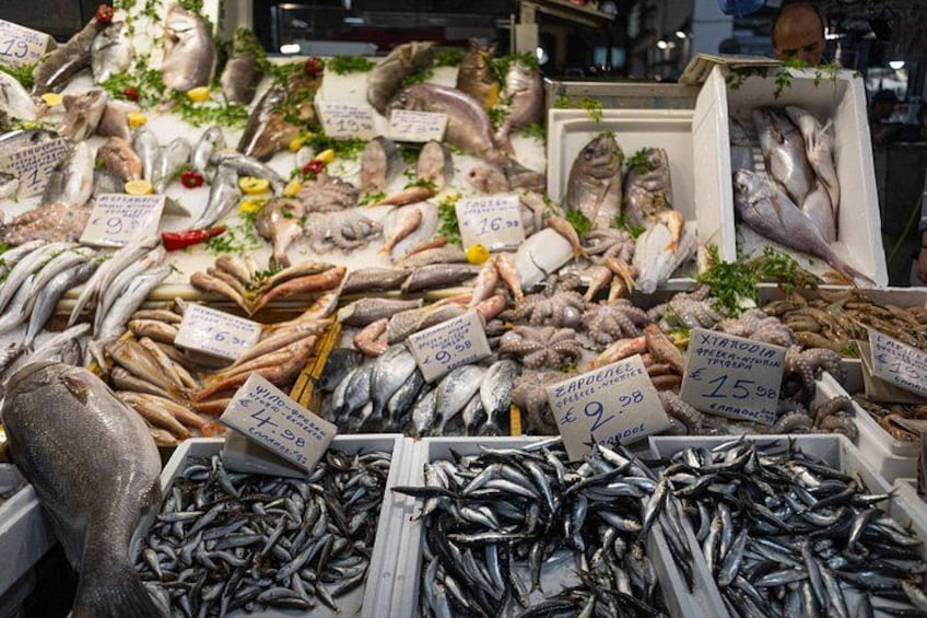 A variety of fresh seafood displayed in a market with price tags. 2
