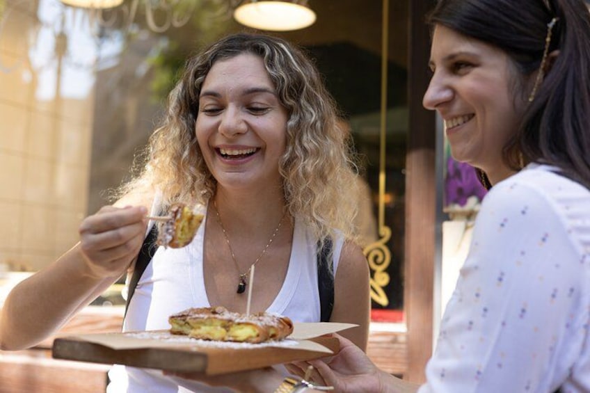 Due persone mangiano cibo all'aperto. 1