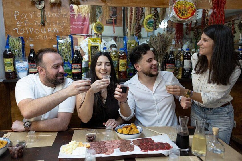 Un grupo de personas en un bar, con comida y bebidas sobre la mesa. 5