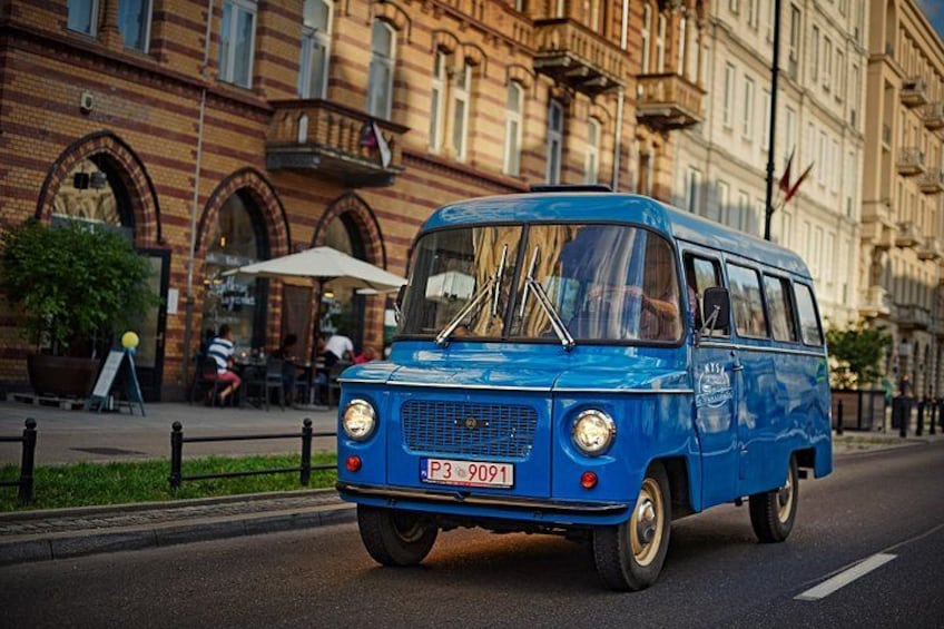 Un furgone vintage blu che percorre una strada cittadina. 2