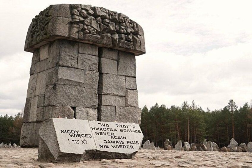 Ein Steins Denkmal mit Inschriften und bewaldeter Umgebung. 2