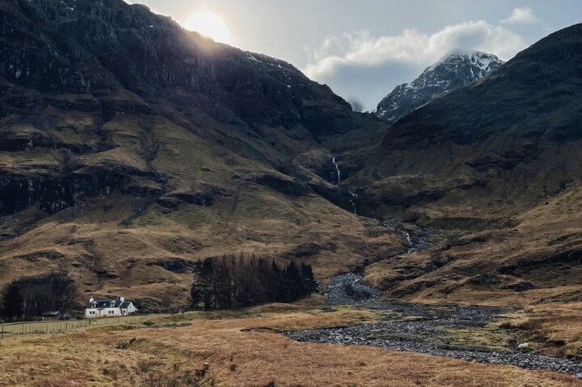 A mountainous landscape with a house, a river, and a waterfall. 3