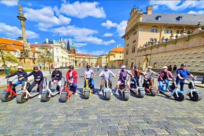 A group of people riding electric unicycles on a cobblestone street in a historic European town. 5