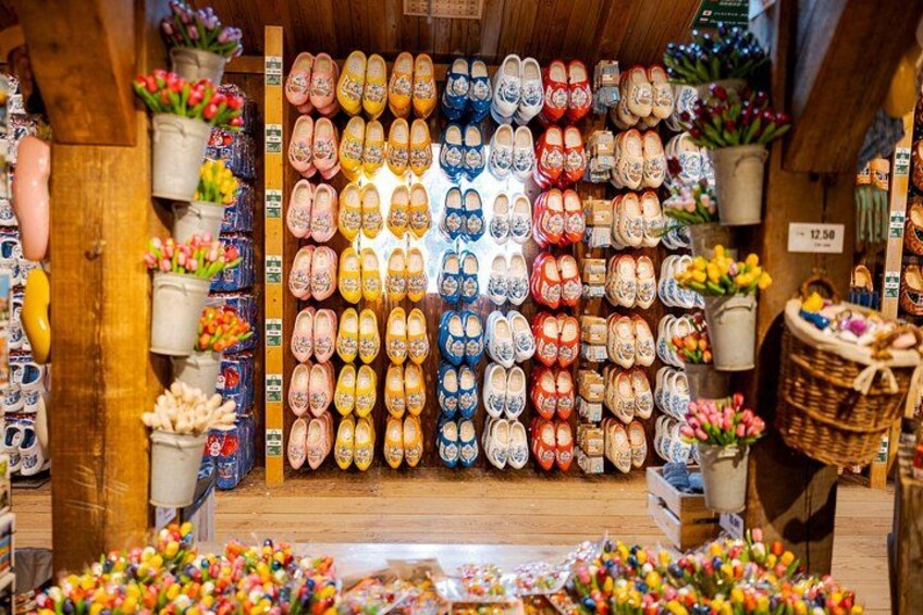 Un negozio di scarpe con file di calzature colorate e composizioni floreali. 2