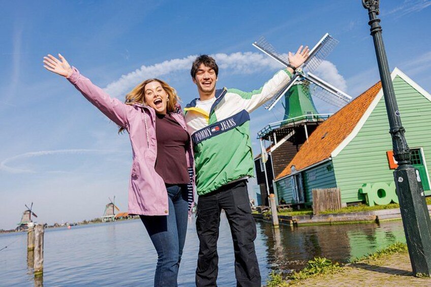 Ein Paar steht vor einer Windmühle, einem grünen Gebäude und einem Kanal. 1