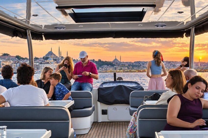 Een boot met mensen die genieten van een zonsondergang met uitzicht op de skyline van een stad. 4