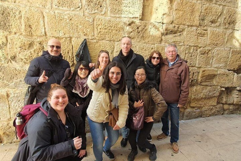 A group of people posing in front of a stone wall. 2