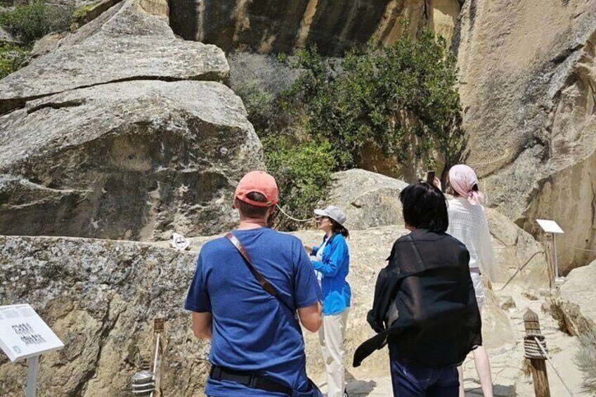 A group of people hiking on a rocky trail with large boulders and sparse vegetation. 4