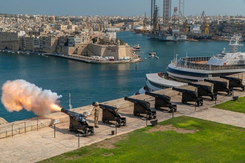 A coastal cityscape with a harbor, ships, and a military cannon firing. 3