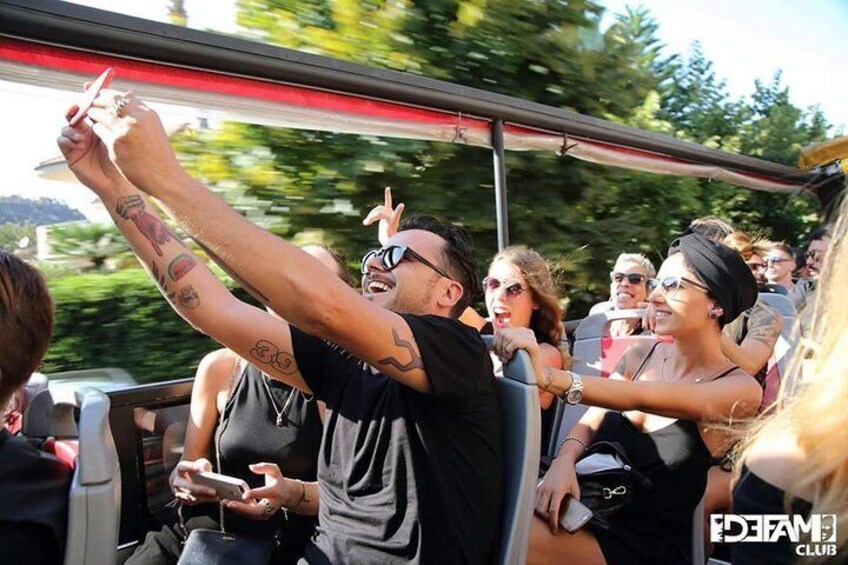 A group of people on a bus, some holding up their hands. 3