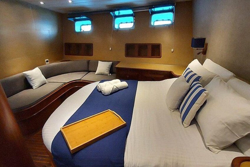 A bedroom with a bed, a sofa, and a wooden tray. 3