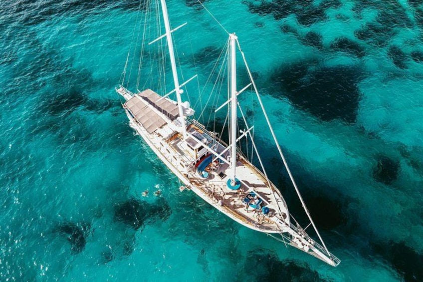A sailboat on turquoise water. 1