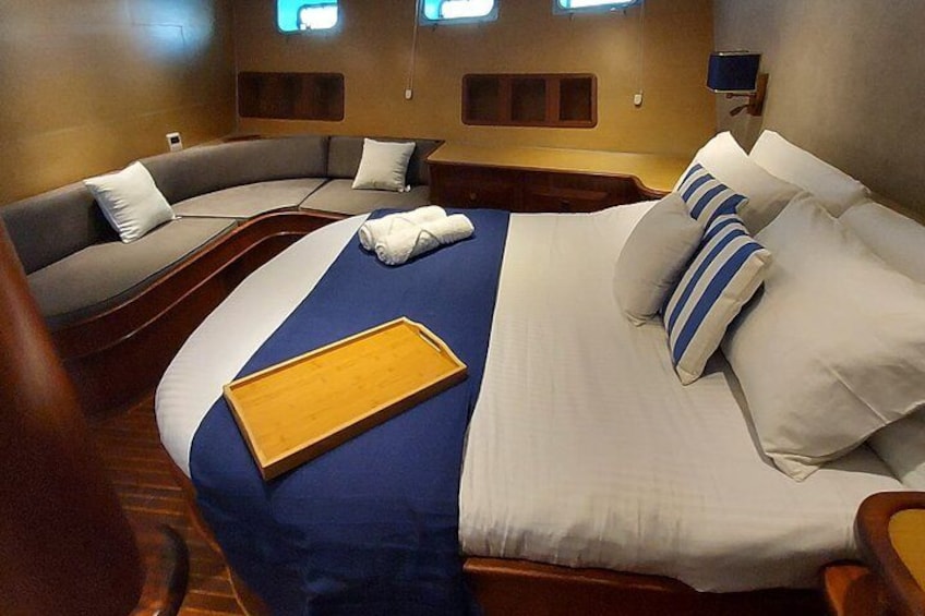 A bedroom with a bed, a sofa, and a tray. 3