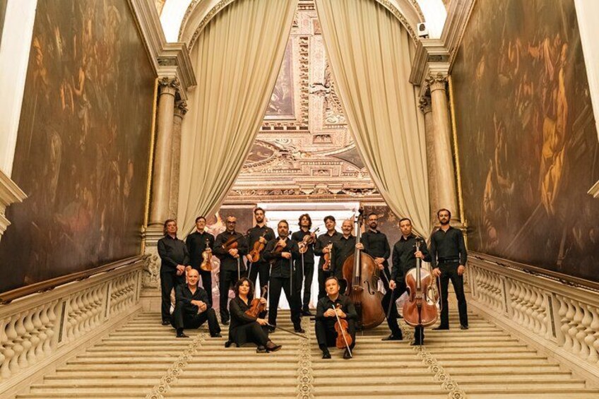 A classical music ensemble in a grand hall with ornate architecture and frescoes. 4