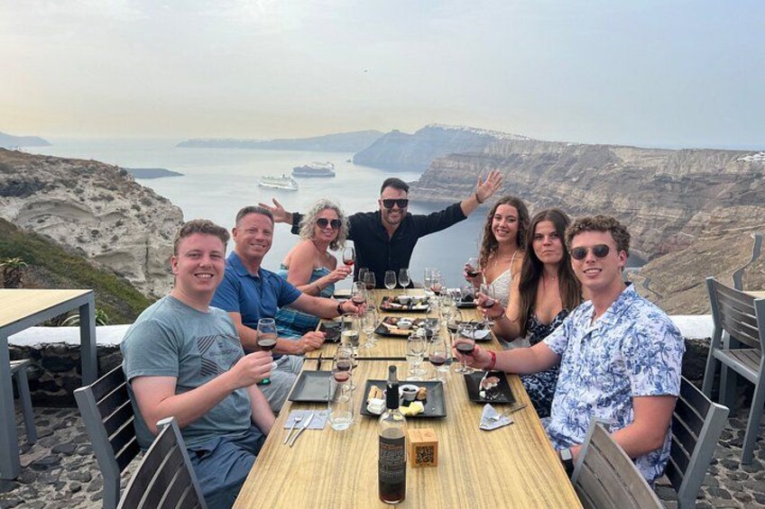Un grupo de personas cenando en una mesa con vista al océano. 1