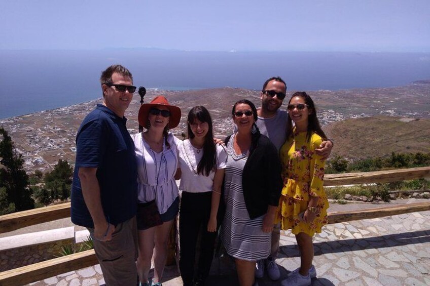 Un grupo de personas sobre una zona empedrada con vistas panorámicas a la costa y tierra firme distante. 3