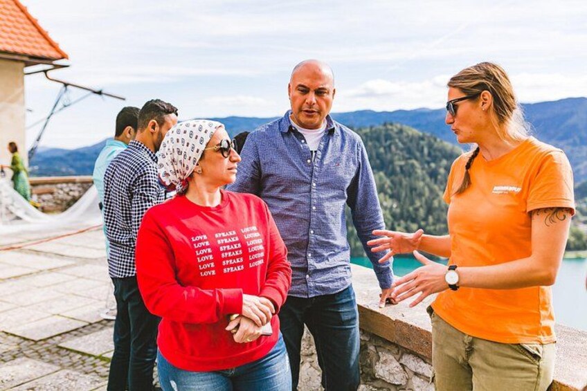 A group of people standing by a lakeside with mountains in the background. 2