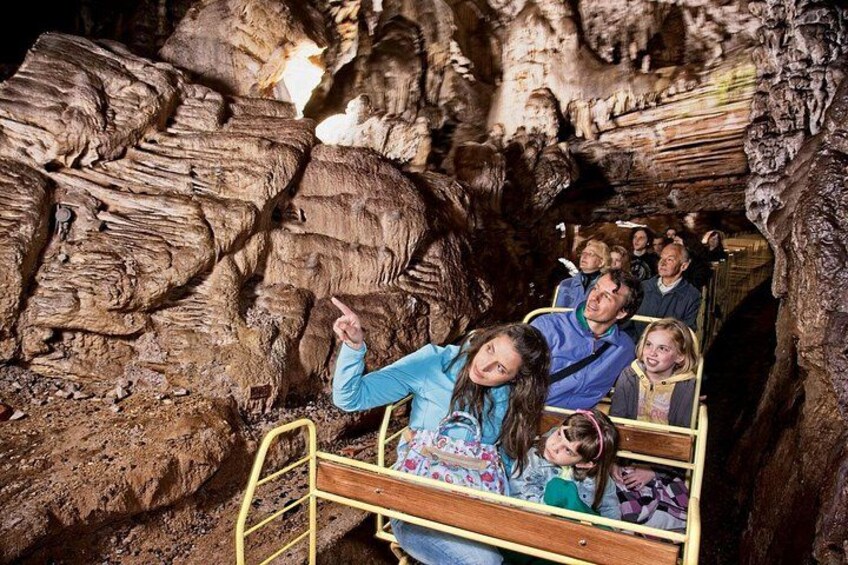 Visita guiada a una cueva con personas sobre una cama de madera. 2