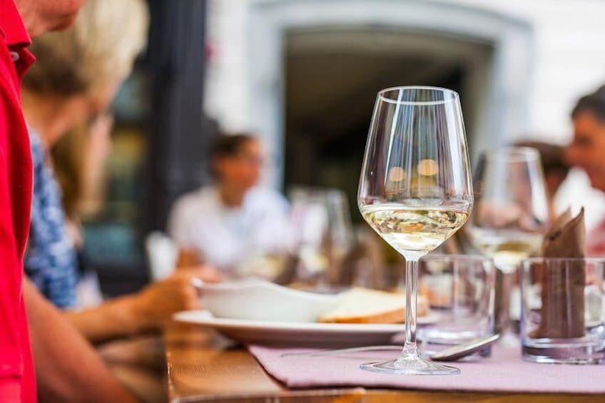A dining table with a wine glass and plates. 4