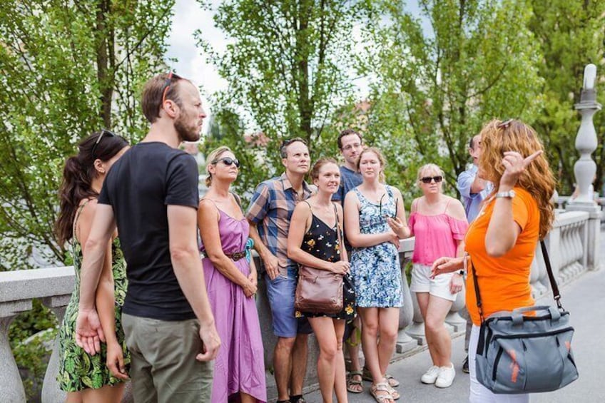 A group of people standing on a bridge with greenery in the background. 2