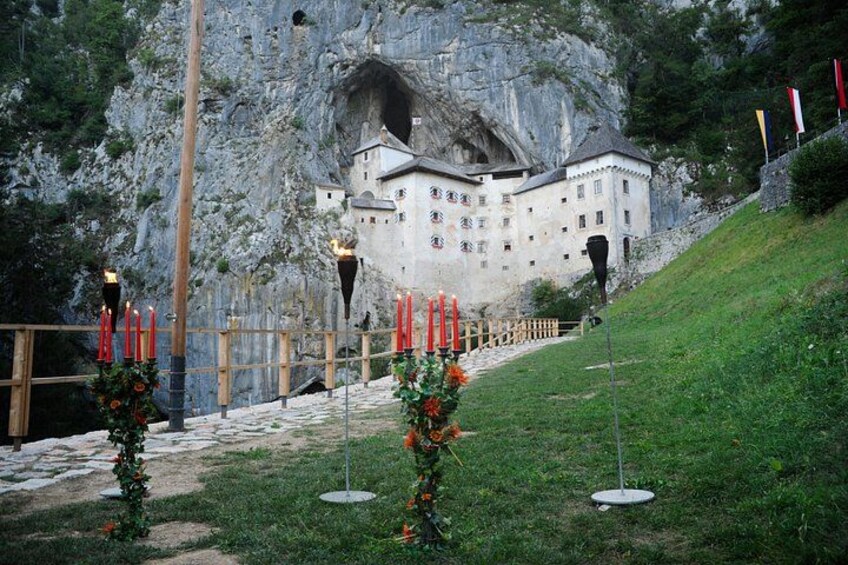 Un château perché sur une colline, décoré de bougies rouges et de verdure. 1