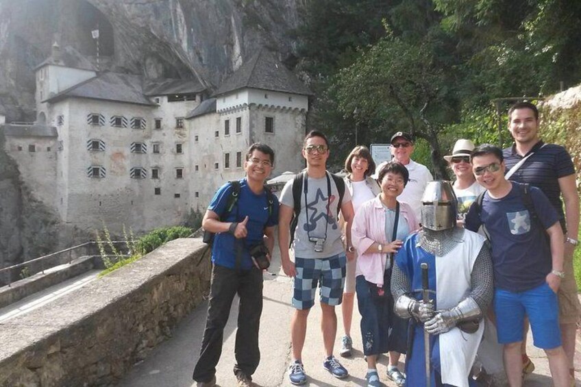 Un groupe de personnes se tient sur un sentier, avec un château en arrière-plan. 5