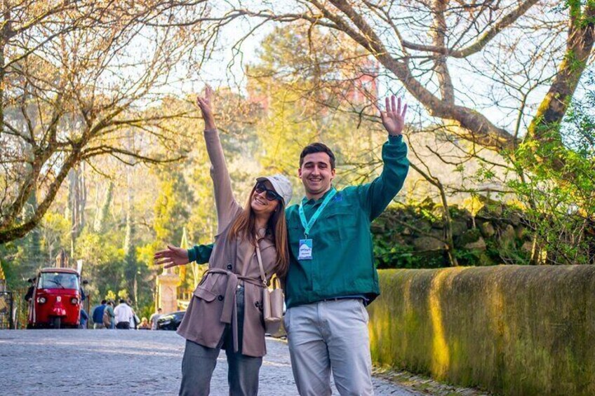Dos personas en un parque con árboles y un muro de piedra. 1
