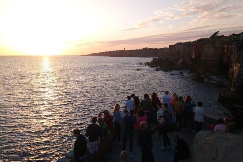 Un grupo de personas de pie junto al mar al atardecer. 4