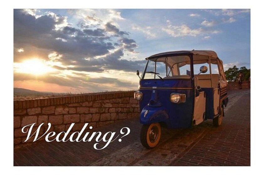A vintage car parked on a brick road with a sunset in the background. 2