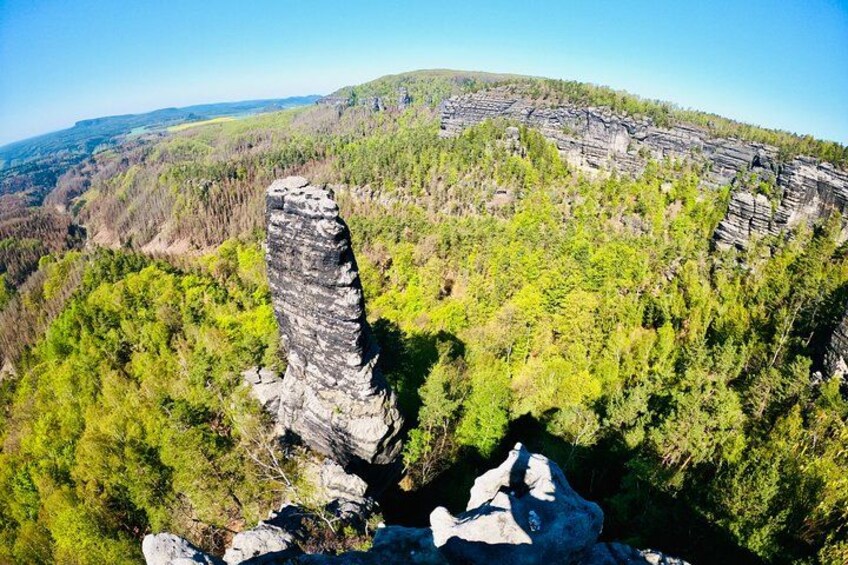 A forested mountain with a prominent rock formation. 2