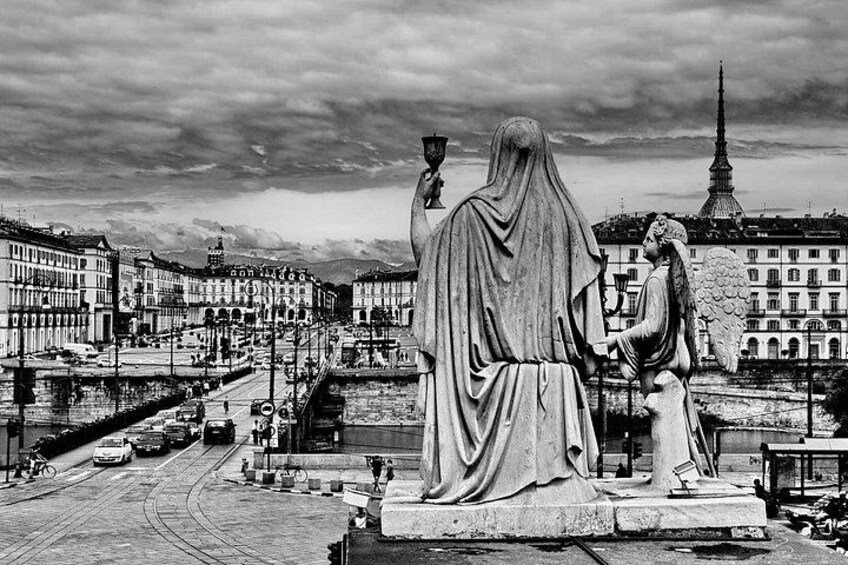 A statue of a woman holding a child, with a cityscape in the background. 4