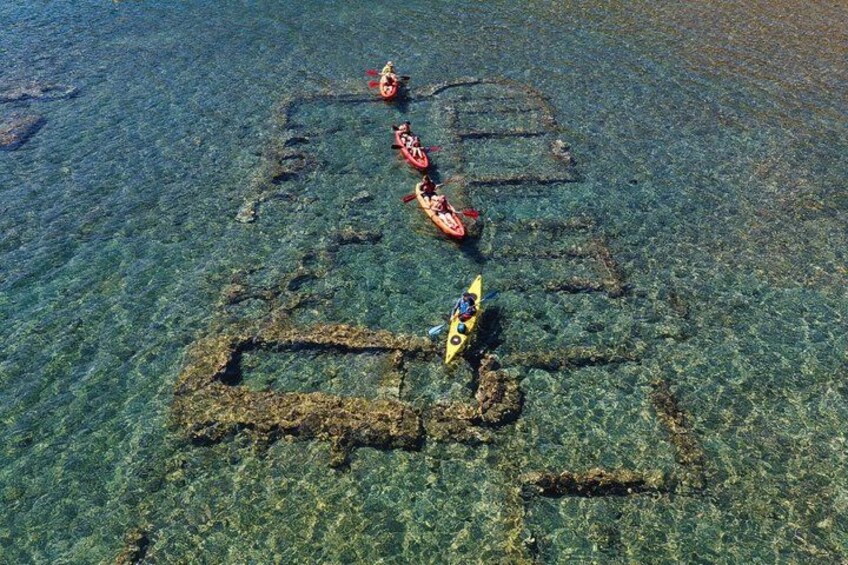 Kayaks on a clear water body with visible underwater structures. 2